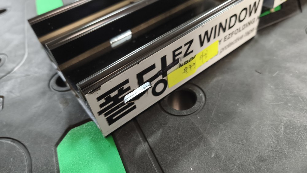 「EZ WINDOW · 폴딩」 보호 필름이 붙은 검은 레일 자재와 노란 메모