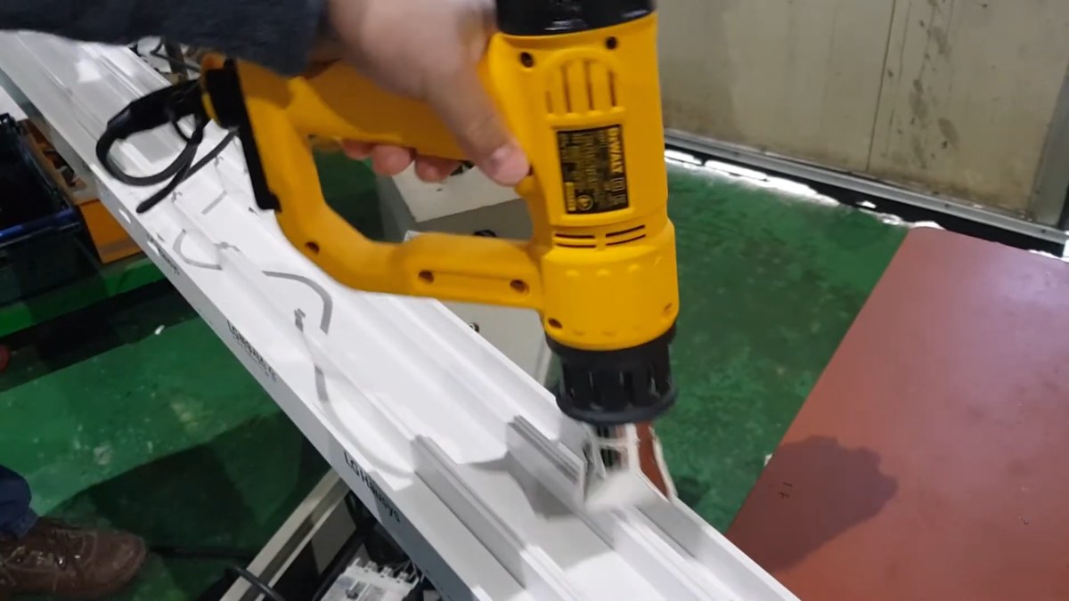 열풍기를 움직이며 PVC 창틀을 데우는 모습